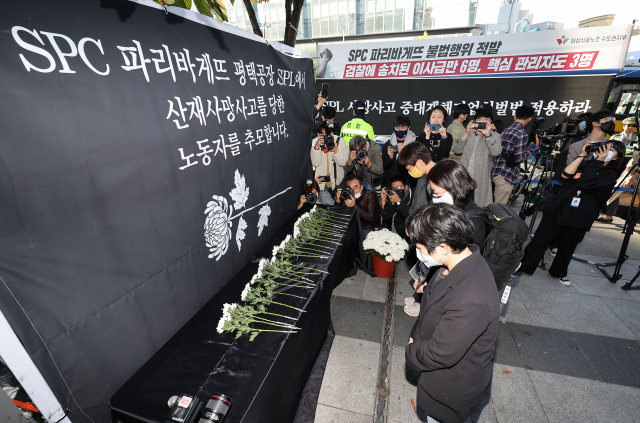 시민들이 20일 오후 서울 양재동 SPC 본사 앞에서 열린 평택 SPC 계열사 SPL의 제빵공장 사망 사고 희생자 서울 추모행사에서 헌화하고 있다. 연합뉴스