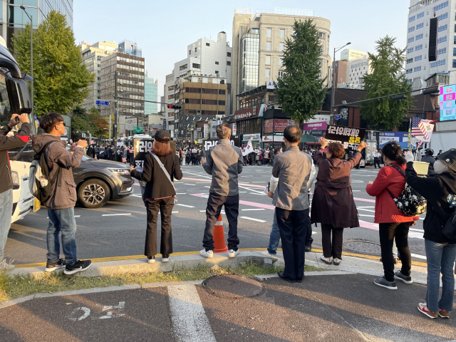 서울 태평로터리에서 22일 오후 자유통일당 집회 참가자들과 촛불전환행동 참가자들이 도로를 사이에 두고 서로의 피켓을 흔들며 대치하고 있다. 박신원 기자