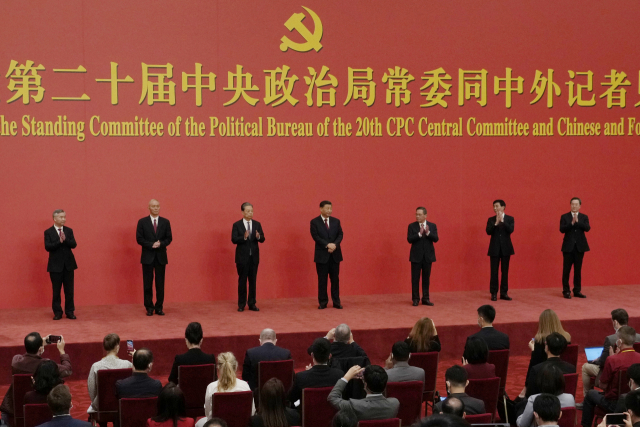 Chinese President Xi Jinping stands as new members of the Politburo Standing Committee applaud at the Great Hall of the People in Beijing, Sunday, Oct. 23, 2022. (AP Photo/Ng Han Guan)