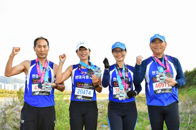 현대자동차 울산공장 마라톤동호회 소속 정남귀 기술주임·오길자 부부와 황영균 기술주임·박계선 부부가 세계 6대 마라톤대회 풀코스를 모두 완주하고 기념촬영을 하고 있다. 사진제공=현대자동차