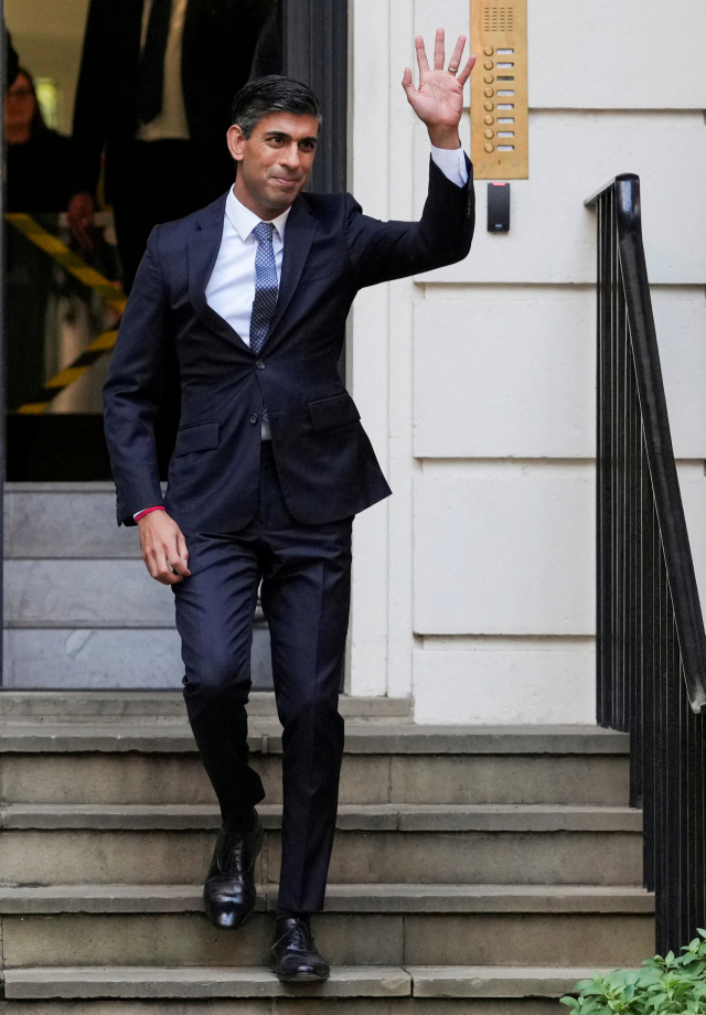 리시 수낵 총리 내정자가 24일(현지 시간) 런던 보수당 선거운동본부에서 손을 들고 걸어 나오고 있다. 로이터연합뉴스