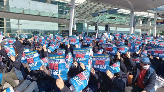 28일 인천공항 제1여객터미널 3층 8번 게이트에서 열린 파업출정식에서 민주노총 공공운수노조 인천공항지역지부 노조원들이 피켓을 들고 흔들고 있다. 이건율 기자