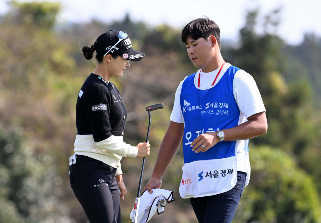 SK네트웍스·서울경제 레이디스 클래식 2라운드를 각각 선수와 캐디로 동반한 ‘예비부부’ 오지현(왼쪽)과 김시우가 카메라를 향해 활짝 웃고 있다. 서귀포=권욱 기자