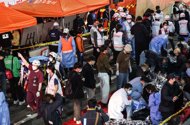 30일 오전 서울 용산구 이태원동에 출동한 119 구조대원들과 의료진들이 부상자들을 구조하고 있다. 연합뉴스