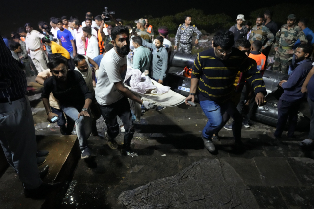 30일(현지시간) 인도 서부 구자라트주 모르비 지역에서 다리 붕괴 사고가 일어난 가운데 자원봉사자들이 31일 희생자를 들것에 실어 옮기고 있다. AP연합뉴스