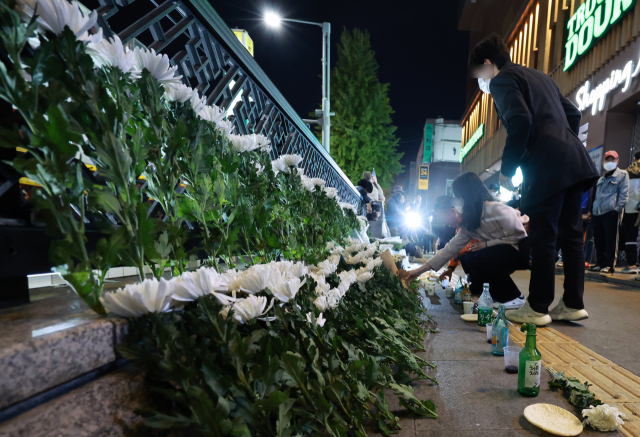 30일 오후 서울 용산구 지하철 6호선 이태원역 1번 출구 앞에 마련된 핼러윈 인파 압사 사고 희생자 추모 공간에서 시민들이 헌화하고 있다. 코로나19 사태 이후 3년 만에 이태원동 일대에서 열린 핼러윈 축제에서 29일 저녁 10만 명의 인파가 몰리며 154명이 압사하는 대형 참사가 벌어졌다. 연합뉴스