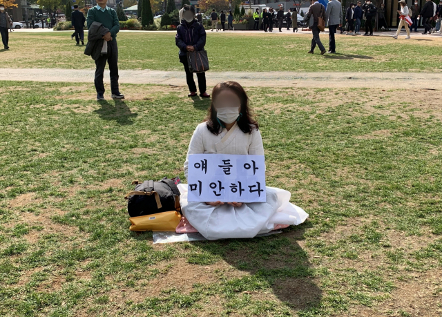 흰 옷을 입은 60대 여성이 31일 오후 “얘들아 미안하다”라고 적힌 피켓을 들고 서울 중구 서울광장에 마련된 이태원 압사사고 희생자 합동분향소를 찾았다. 김남명 기자