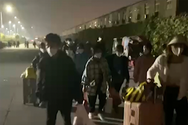 중국 허난성 정저우의 폭스콘 공장에서 29일 여행 가방과 짐 가방을 든 사람들이 떠나고 있다. AP연합뉴스