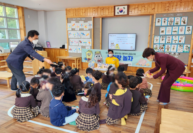 BNK경남은행 금융소비자보호부 직원들이 현동세종유치원 어린이들에게 돈과 저축을 주제로 한 어린이 금융교육 프로그램 ‘돈이랑 놀자’를 진행하고 있다. /사진제공=경남은행