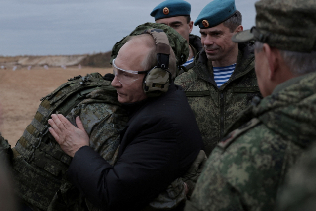 블라디미르 푸틴(왼쪽 두 번째) 러시아 대통령이 20일(현지시간) 랴잔주 서부군관구 동원예비군 훈련소를 방문해 한 사병을 껴안고 있다. AP연합뉴스