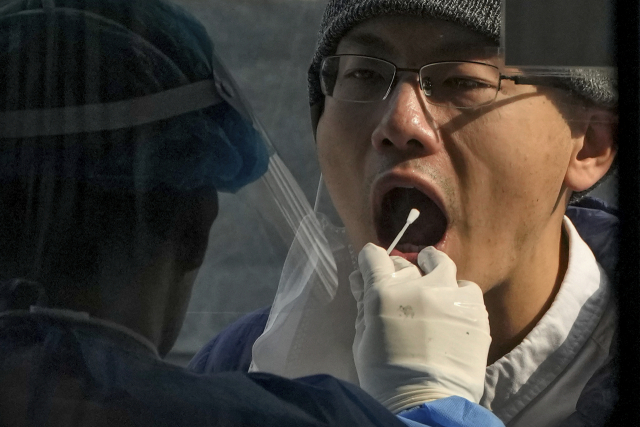 베이징의 코로나바이러스 검사장에서 2일 의료진이 한 남성으로부터 샘플을 채취하고 있다. AP연합
