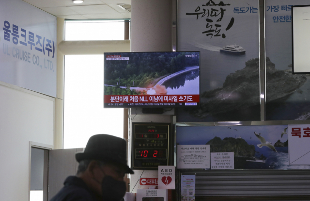 3일 경북 울릉군 울릉읍 사동항 여객선터미널에 설치된 TV로 북한 미사일 관련 뉴스가 나오는 가운데 여행객이 TV 앞을 지나가고 있다. 이날도 북한이 동해상으로 탄도미사일을 발사했다고 합동참모본부가 밝혔다./연합뉴스
