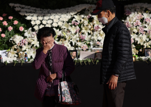 한 어르신이 4일 서울광장에 마련된 이태원 참사 희생자 합동 분향소에서 헌화를 한 뒤 눈물을 훔치고 있다. 연합뉴스