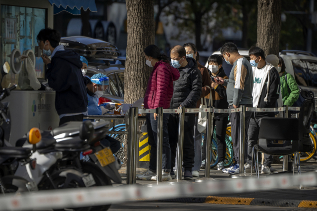 중국 베이징 시민들이 4일(현지 시간) 코로나19 검사를 위해 마스크를 쓴 채 줄을 서고 있다. 중국의 제로 코로나 정책이 언제 끝나느냐는 글로벌 경제에 미치는 영향이 크다. AP연합뉴스