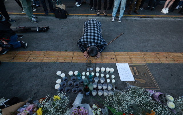 30일 오후 서울 용산구 지하철 6호선 이태원역 1번 출구 앞에 마련된 '핼러윈 인파' 압사 사고 희생자 추모 공간에서 한 시민이 절을 하고 있다. /연합뉴스