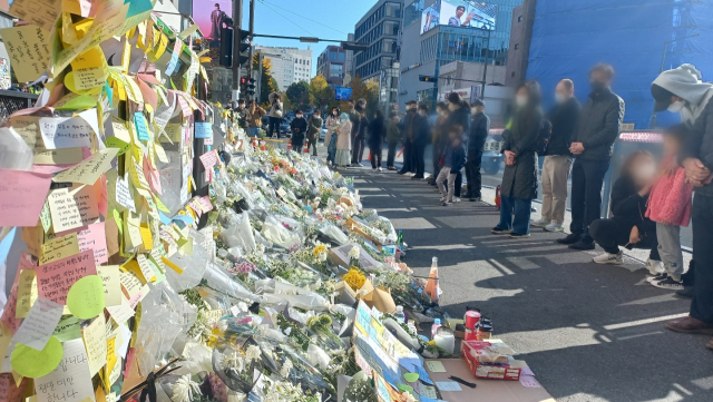 시민들이 6일 서울 용산구 이태원동 이태원역 1번출구에 마련된 추모공간에서 이태원 참사 희생자들을 애도하고 있다. 이건율 기자