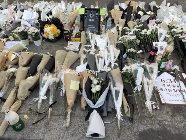 5일 이태원역 1번 출구 추모공간 인근 도로에 흰 국화꽃과 편지가 놓여 있다. 박신원 기자