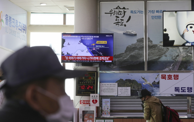 지난 3일 경북 울릉군 울릉읍 사동항 여객선터미널에 설치된 TV로 북한 미사일 관련 뉴스가 나오는 가운데 여행객이 TV 앞을 지나가고 있다. 연합뉴스