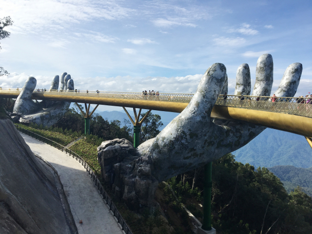 베트남 다낭의 유명 관광지인 바나힐 골든브리지를 관광객들이 걷고 있다. 돌로 만든 거대한 손이 다리를 떠받치고 있는 것이 특징이다. 사진 제공=하나투어