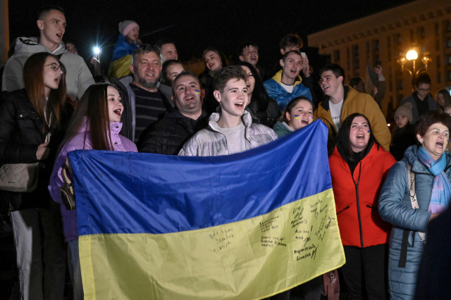 우크라이나 시민들이 헤르손 수복을 기뻐하며 국기를 들어보이고 있다. /AFP연합뉴스