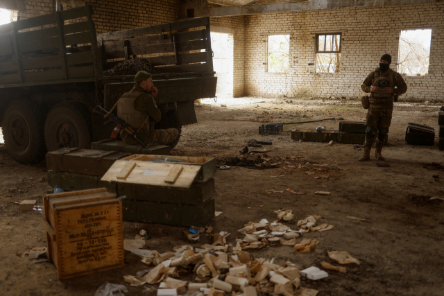우크라이나 군인들이 수복된 헤르손 지역의 한 마을에서 확보한 러시아 군인들의 총기를 살펴보고 있다. /로이터연합뉴스