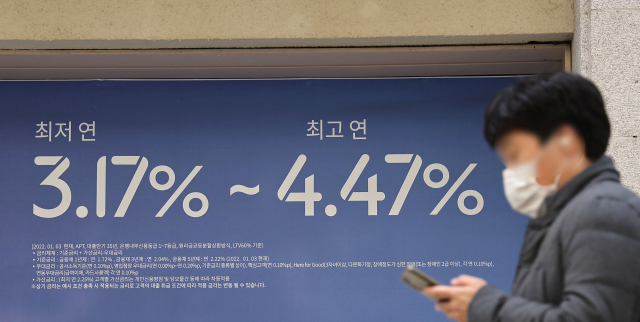 지난 10일 서울의 한 시중 은행에 붙은 주택담보대출 상품 홍보 현수막 앞을 시민이 지나치고 있다. /연합뉴스