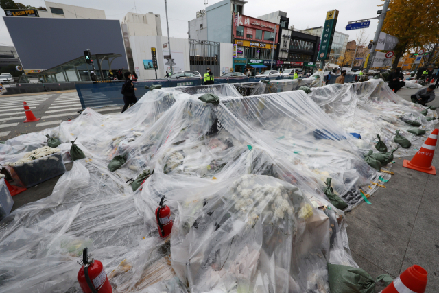13일 서울 용산구 이태원 참사 현장 인근에 마련된 추모공간이 지난밤 내린 비를 막기 위해 비닐로 덮여 있다. 연합뉴스