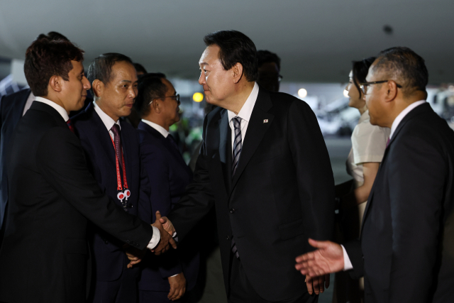 윤석열 대통령과 김건희 여사가 주요 20개국(G20) 정상회의 참석을 위해 13일(현지시간) 인도네시아 발리 응우라 라이 국제공항에 도착, 인사하고 있다. 연합뉴스