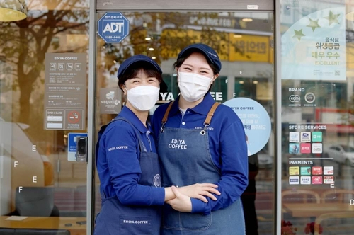 (서울=연합뉴스) = 이디야커피 수원망포점에서 정소영 점주(왼쪽)와 최효빈 메이트가 이디야 메이트 희망기금 전달 기념촬영을 하고 있다. 사진 제공=이디야커피