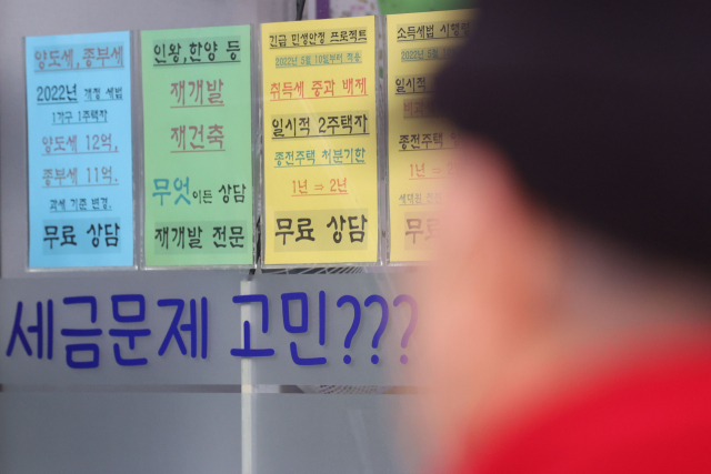 한 시민이 서울의 한 공인중개업소 앞을 지나고 있다. 연합뉴스