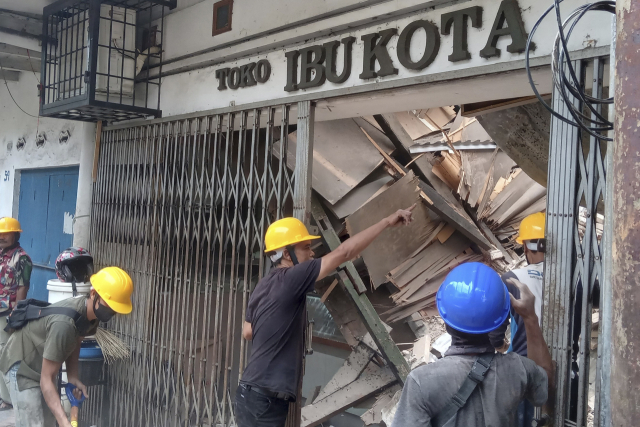 21일 인도네시아 서자바주 치안주르에서 소방당국 관계자들이 지진으로 무너진 건물 안을 조사하고 있다. AP연합뉴스