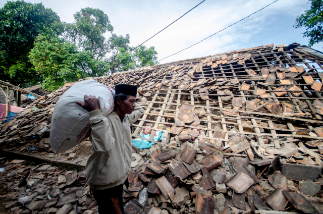 인도네시아 서자바주 치안주르의 한 주민이 22일(현지 시간) 이 지역에서 전날 발생한 규모 5.6의 강진으로 파손된 집을 지나가고 있다. 신화연합뉴스