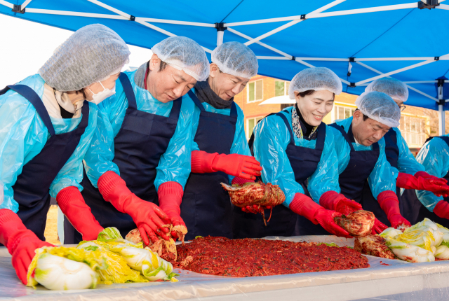 권준학(왼쪽 두 번째) NH농협은행장과 강봉구(왼쪽 세 번째) 삼성전자 한국총괄 부사장이 22일 경기도 수원시 소재 사회복지법인 경동원에서 ‘사랑의 김장김치 및 쌀 나눔 행사’에 참여하고 있다. 사진 제공=NH농협은행