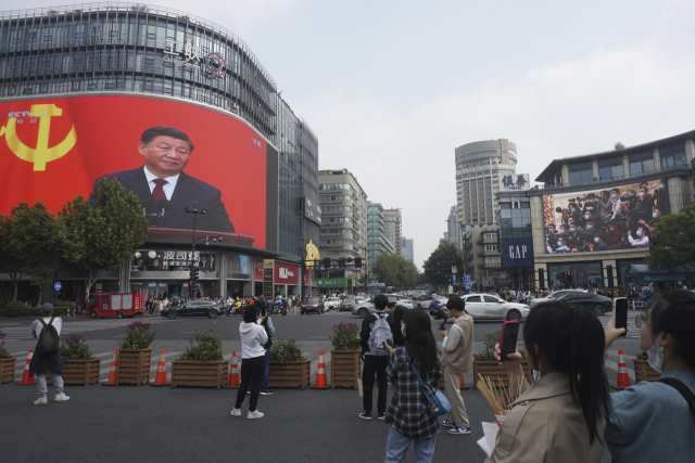 10월 23일 중국 저장성 항저우의 상업지구에 설치된 대형 스크린에 시진핑 국가주석의 이미지가 비치고 있는 모습.=차이나토픽스