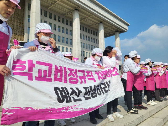 전국학교비정규직노동조합 급식실 조합원들이 8일 서울 영등포구 국회 본관 계단에서 학교급식실 폐암 산재 대책 마련과 노동환경 개선 예산 편성을 요구하며 기자회견 하고 있다. 연합뉴스