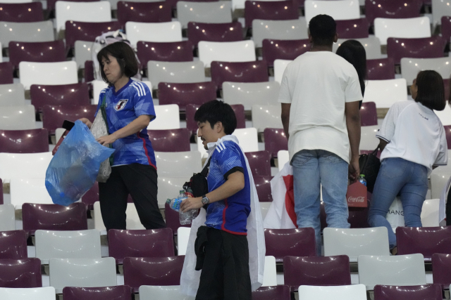 23일 2022 카타르 월드컵 조별리그 E조 1차전 독일과 일본의 경기가 끝난 후 일본 팬들이 각자 봉지를 들고 주변을 정리하고 있다. AP연합뉴스