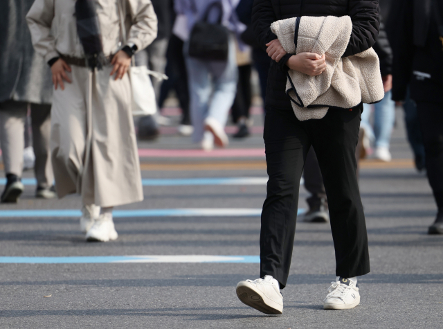 큰 추위 없는 늦가을 날씨가 이어지고 있는 21일 오후 겉옷을 손에 든 시민들이 광화문네거리를 지나고 있다. 연합뉴스