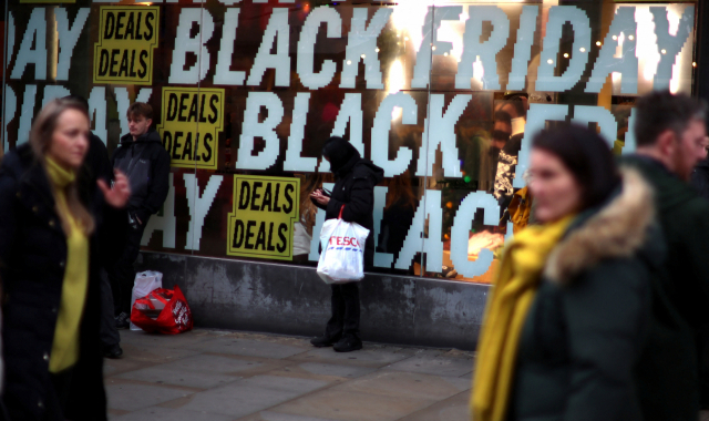 26일(현지 시간) 영국 맨체스터에서 블랙프라이데이 할인 행사를 하는 한 매장 앞을 시민들이 지나가고 있다. 로이터연합뉴스