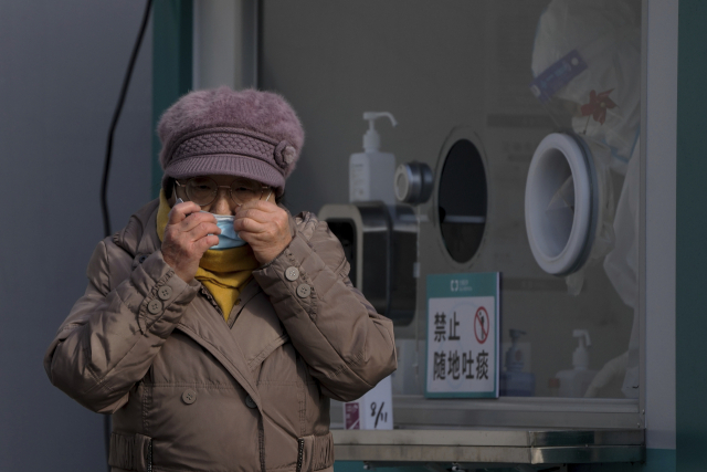 한 여성이 29일 베이징에서 코로나19 유전자증폭(PCR) 검사를 마치고 마스크를 고쳐 쓰고 있다. AP연합