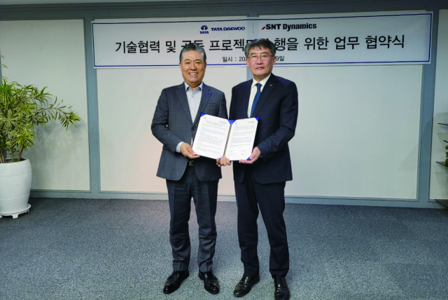박재석(오른쪽) SNT중공업 대표이사와 김방신 타타대우상용차 대표이사가 29일 전략적 파트너십을 체결한 후 기념촬영을 하고 있다./사진제공=SNT