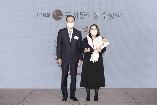 이광복(왼쪽) 동서식품 대표이사가 대상을 수상한 김은혜 씨에게 상장과 상패를 수여하고 있다. 사진 제공=동서식품