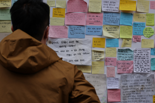 10·29 참사 이후 한 달여가 지난 28일 한 시민이 서울 용산구 이태원동 사고 현장에서 시민들의 추모 글을 읽고 있다. 연합뉴스