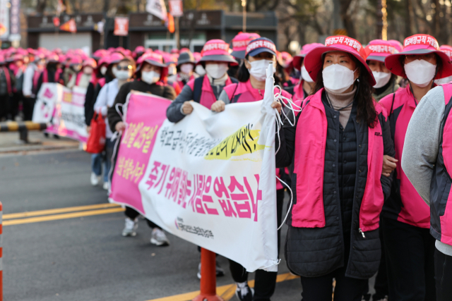 전국학교비정규직노동조합 조합원들이 25일 오후 서울 영등포구 여의대로에서 국회로 행진하고 있다. 이들은 정규직과의 임금 차별 해소와 급식실 폐암 종합대책 마련, 교육교부금 축소 반대 등을 주장했다. 연합뉴스