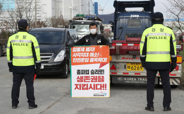 1일 오후 인천시 중구 삼표시멘트 인천사업소 앞에서 화물연대 노조원이 피켓을 들고 경찰관들과 대치하고 있다. 연합뉴스