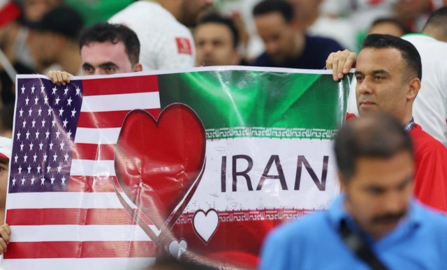 지난달 29일 오후(현지시간) 카타르 도하 앗수마마 스타디움에서 열린 2022 카타르 월드컵 B조 조별리그 3차전 이란과 미국의 경기. 축구팬들이 미국과 이란 국기가 그려진 피켓을 들고 있다. 연합뉴스 캡처