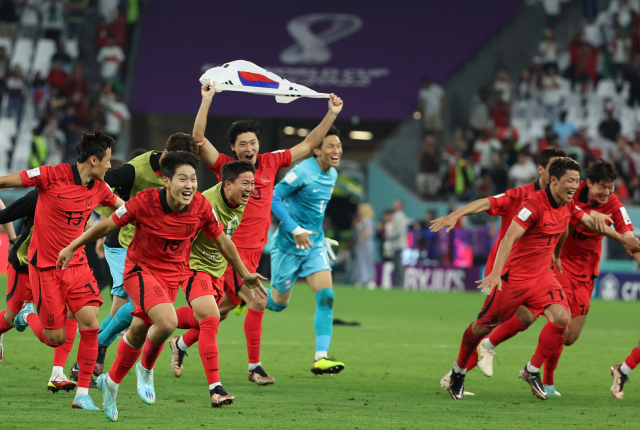 3일 오전(한국시간) 카타르 알라이얀의 에듀케이션 시티 스타디움에서 열린 2022 카타르 월드컵 조별리그 H조 3차전 대한민국과 포르투갈 경기에서 승리를 거두며 16강 진출에 성공한 대표팀 황희찬, 조규성 등 선수들이 태극기와 함께 그라운드를 달리며 기쁨을 만끽하고 있다. 연합뉴스