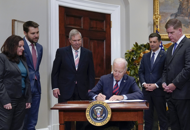 조 바이든 대통령이 2일(현지 시간) 백악관 루즈벨트 룸에서 각료와 참모들이 지켜보는 가운데 철도파업 저지 법안에 최종 서명하고 있다. AP연합뉴스