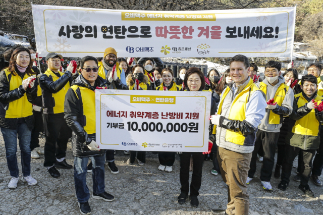 구자범(앞줄 왼쪽) 오비맥주 수석부사장을 비롯한 임직원들이 2일 서울 강남구 구룡마을에서 연탄 나눔 봉사 활동을 한 뒤 기념 촬영을 하고 있다. 사진 제공=오비맥주