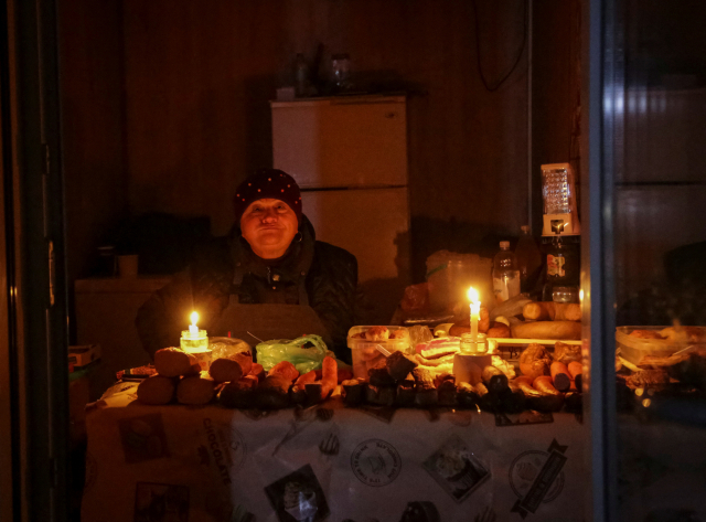 우크라이나 오데사의 한 상점 주인이 5일(현지시간) 러시아의 공습으로 전기가 끊기자 초를 켠 채 장사를 하고 있다. 로이터연합뉴스