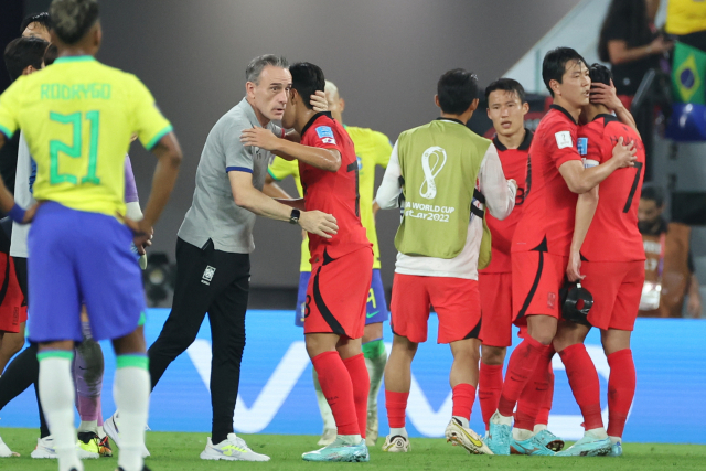 파울루 벤투(왼쪽) 감독이 6일 카타르 월드컵 16강 브라질전 뒤 선수 한 명 한 명을 안아주고 있다. 연합뉴스